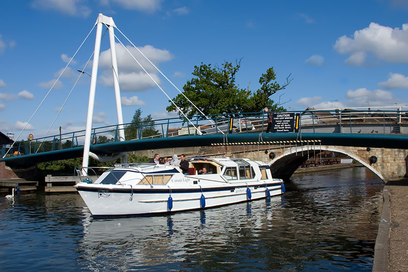 A cruiser navigating Wroxham Bridge on the River Bure